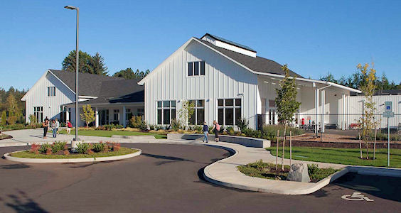 Community center with a parking lot and landscaping